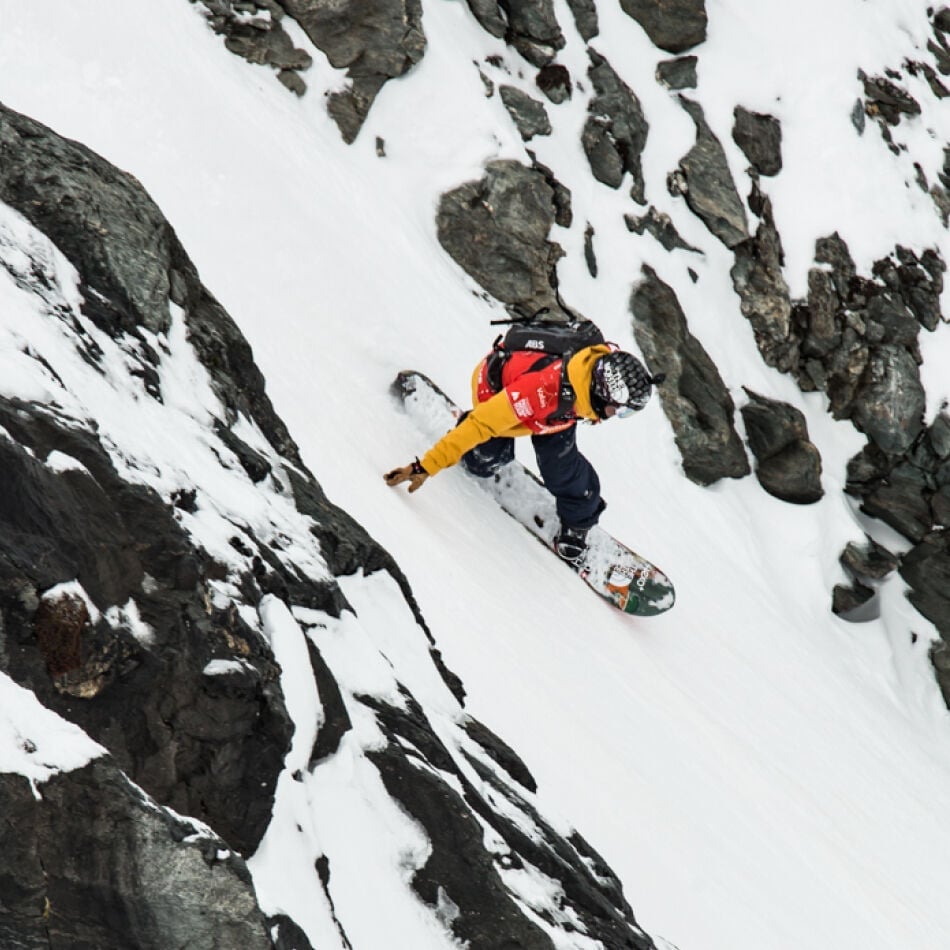Xavier De Le Rue freeriding between rocks on the mountain