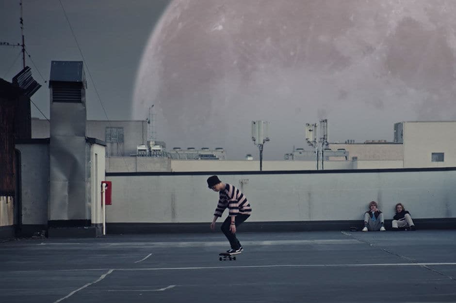 Man skating on a basket court with moon in the background 