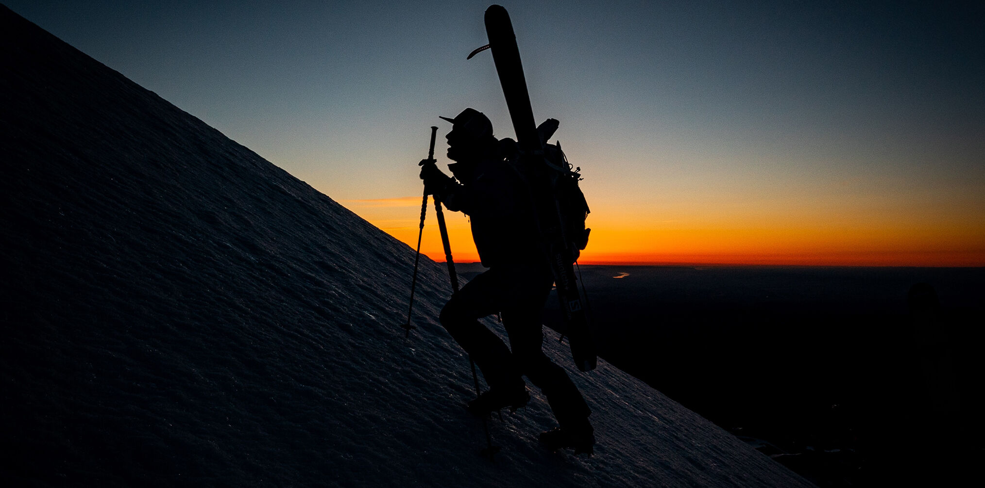 Cody Townsend is hiking a mountian during the sunset