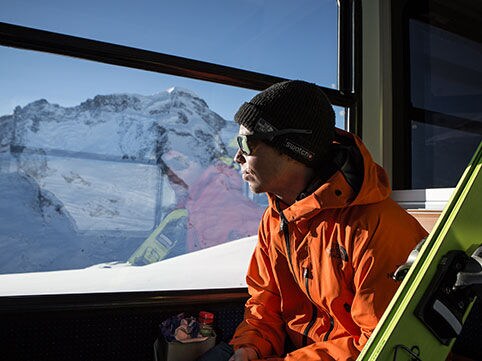 Sam Anthamatten is looking at the mountain while seating in a train