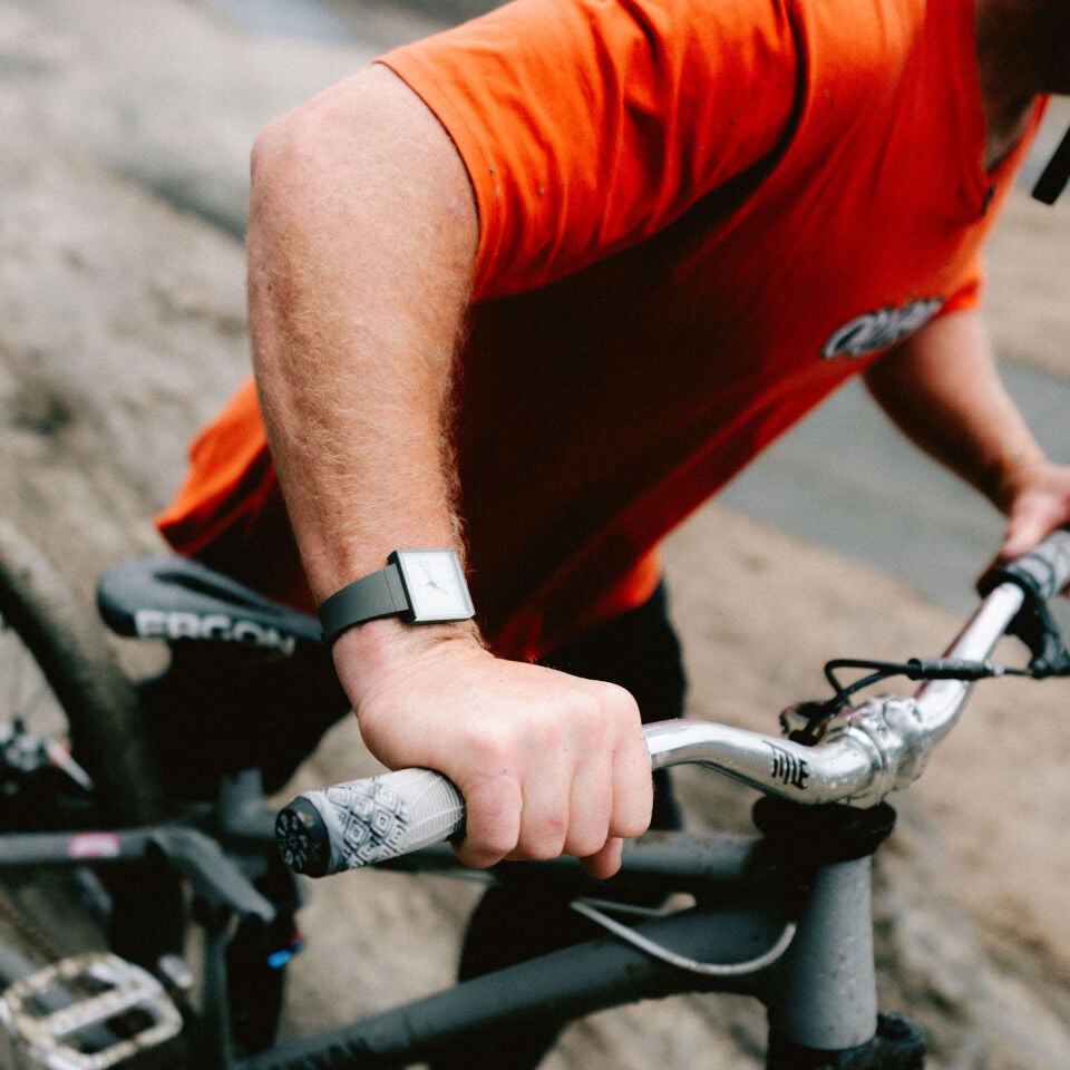 Proteam freeride MTB athlete Sam Pilgrim on dirt road bike ride at Swatch Nines MTB event with WHAT IF…GREEN? Swatch watch.