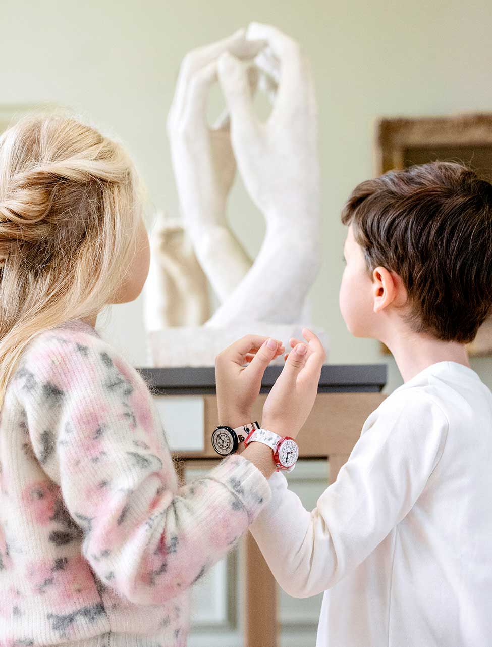 Kids recreating a sculpture with their hands