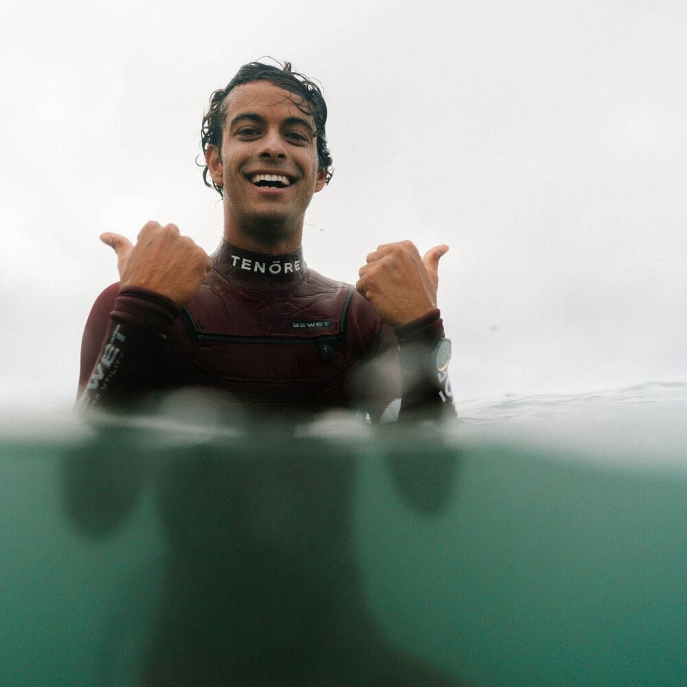 Noah Beschen in the water, smiling with thumbs up