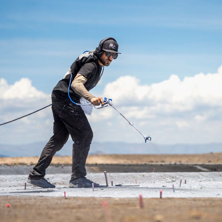 Artist Saype painting on the desert ground Artist Saype painting on the desert ground