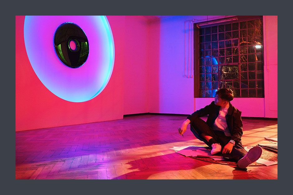 Man sitting on the floor watching at the colored wall