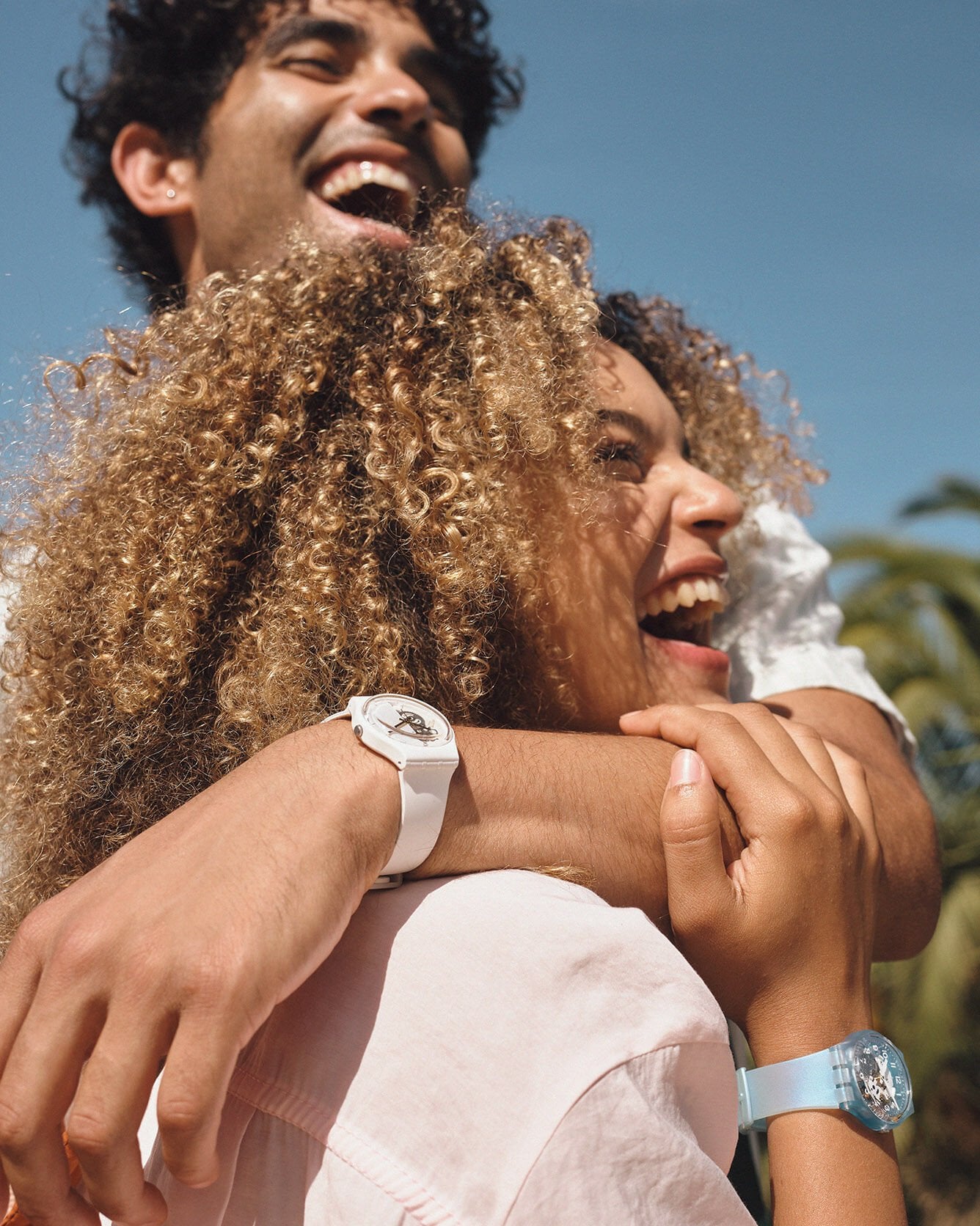 Couple laughing and wearing Swatch watches